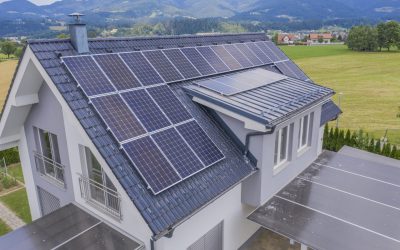 A high angle shot of a private house situated in a valley with solar panels on the roof